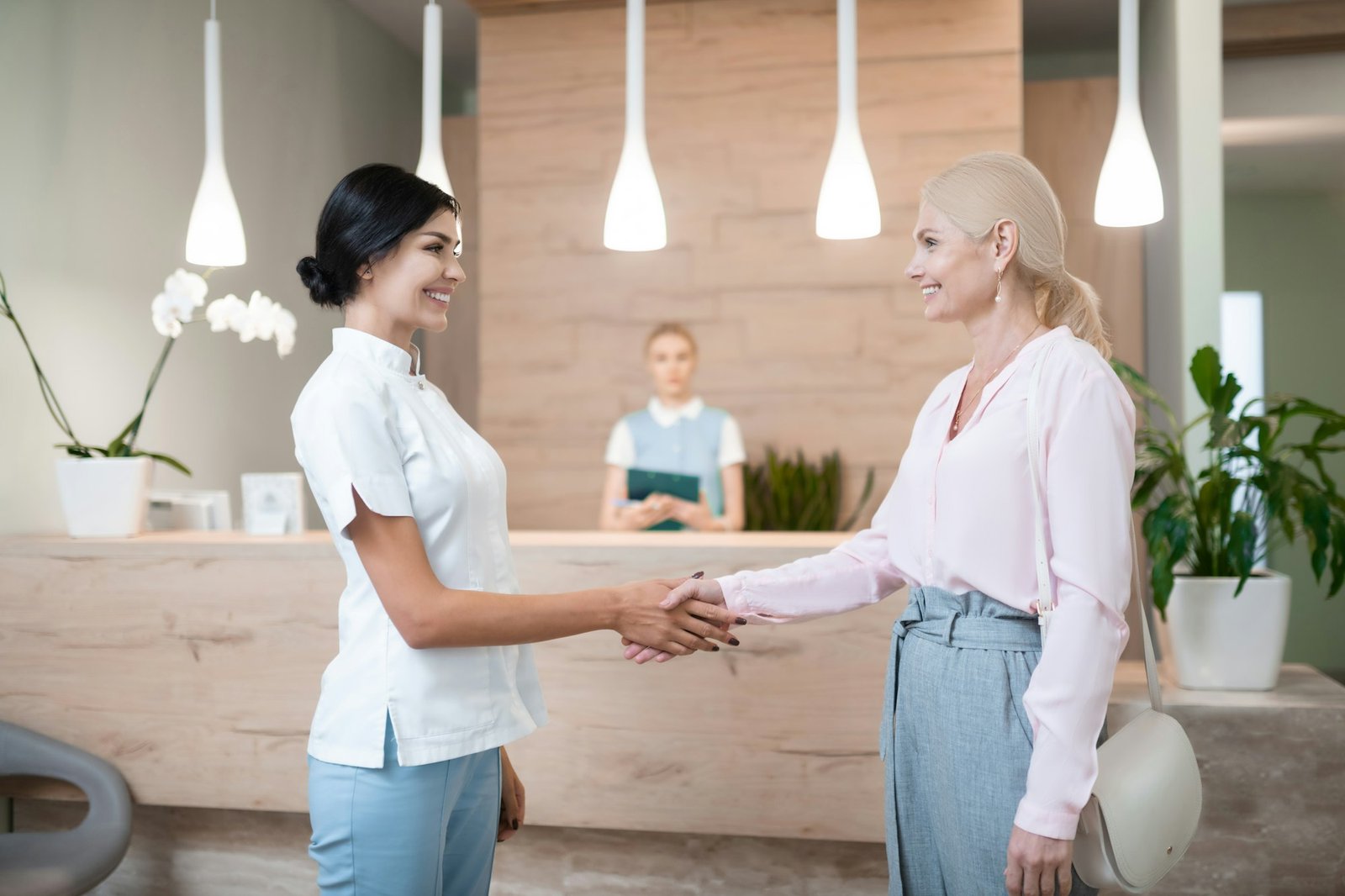 Cheerful woman saying goodbye to her dentist